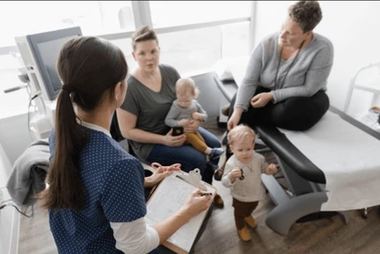Child-development-milestones "Mother and pediatrician discussing child developmental delays and screening for early signs of delays"